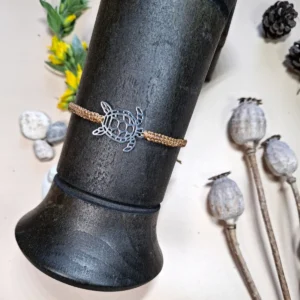 Náramek micro macrame s nerezovým přívěskem ve tvaru želvy. Barva béžová.